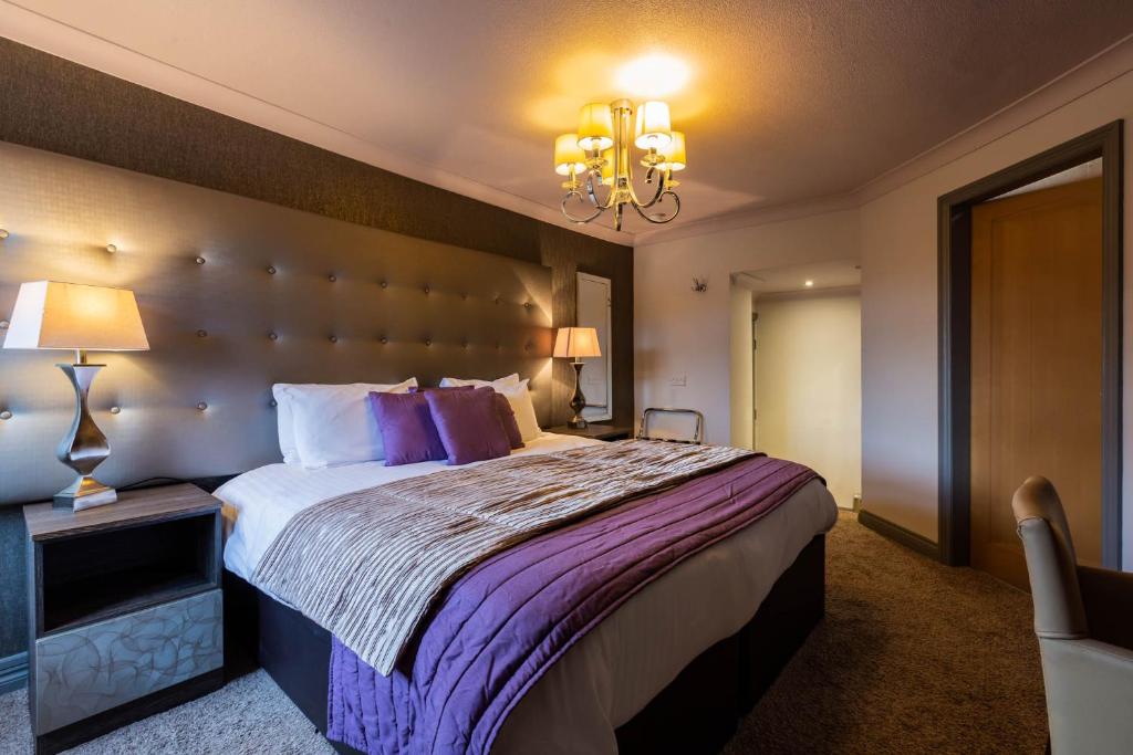 a bedroom with a large bed and a chandelier at The White Swan in Scotter