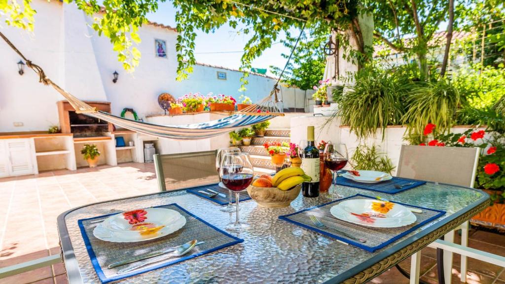 uma mesa com dois pratos de comida e taças de vinho em La Casa del Real de la Jara by Ruralidays em El Real de la Jara