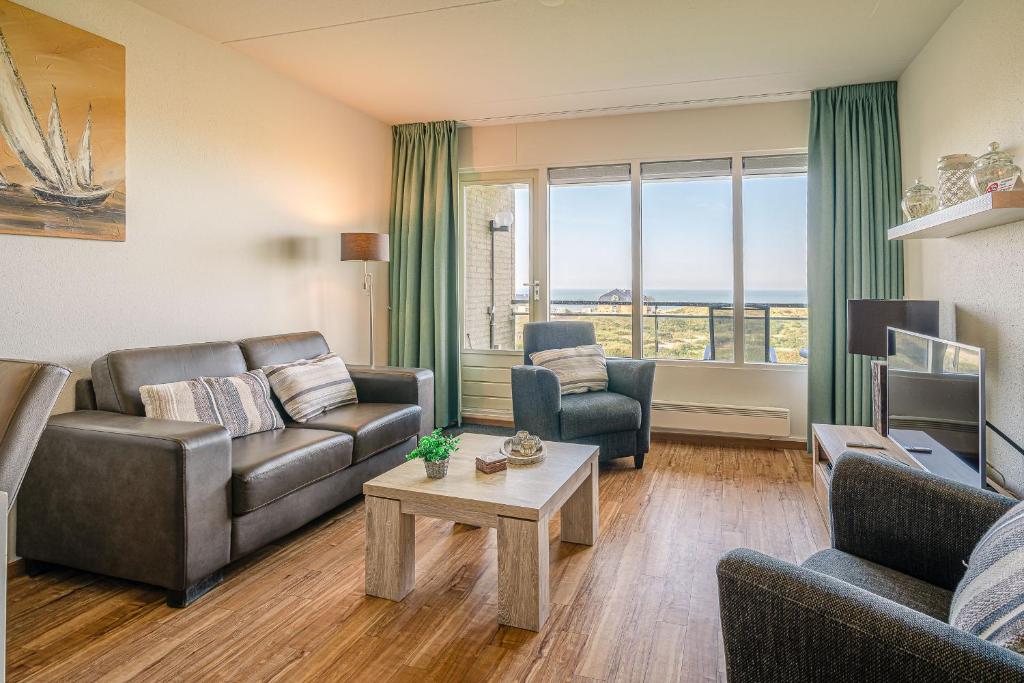 ein Wohnzimmer mit einem Sofa und einem Tisch in der Unterkunft Appartementencomplex Juliana 102 in De Koog