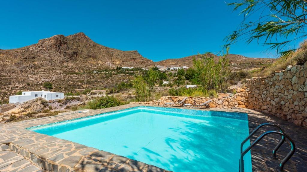 a swimming pool with a mountain in the background at Casa Molino los Arcos Nijar by Ruralidays in Níjar