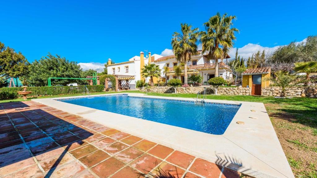 une maison avec une piscine dans une cour dans l'établissement Cortijo Los Tulipanes Periana by Ruralidays, à Periana