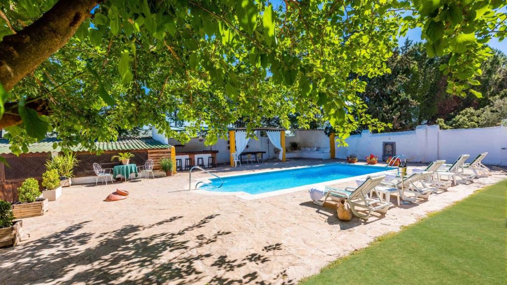 - une piscine avec des chaises longues et une table dans l'établissement Cortijo La Vega Archidona by Ruralidays, à Archidona