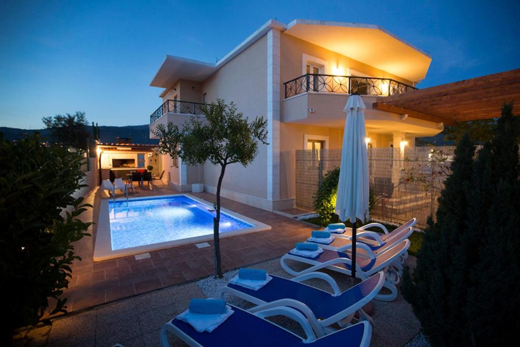 een villa met zwembad voor een huis bij Apartment Sasso in Split