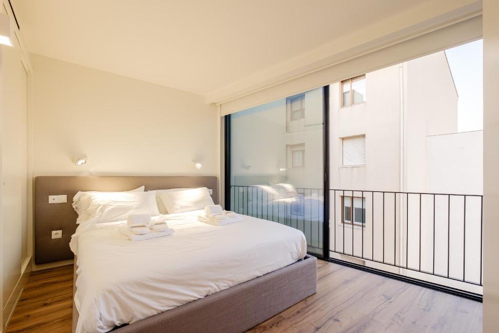 a bedroom with a bed and a large window at BOUTIQUE Rentals- ATTICO Luxury Design-Ocean views in Porto