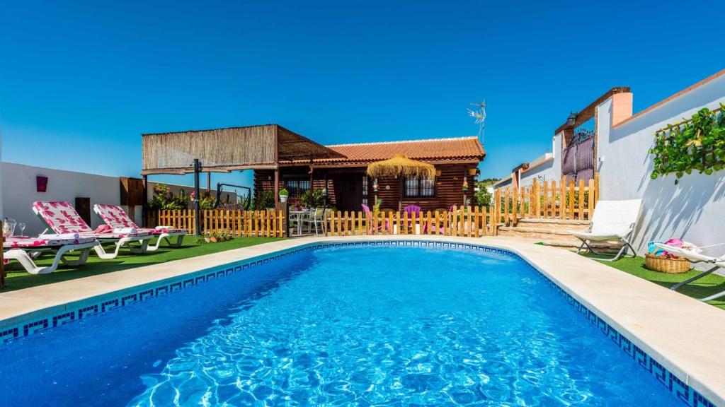 - une piscine avec des chaises et une maison dans l'établissement Casita de Madera Ardales by Ruralidays, à Ardales