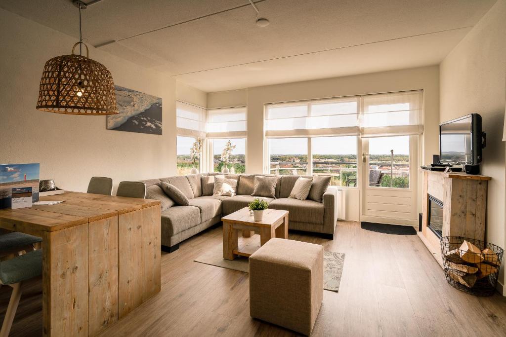 uma sala de estar com um sofá e uma mesa em Appartementencomplex Juliana 130 em De Koog