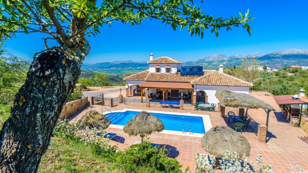 een villa met een zwembad en een huis bij Mansion Piedras Blancas Colmenar by Ruralidays in Colmenar