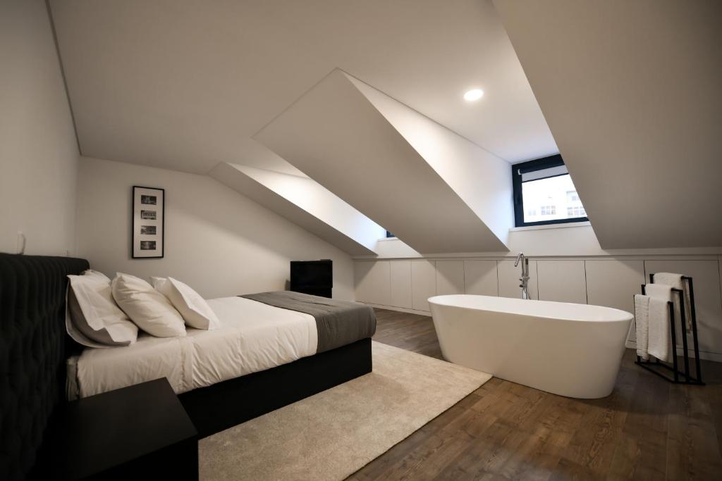 布拉加的住宿－PALHOTAS GUEST HOUSE - Suite Premium Bom Jesus，一间卧室配有一张床和浴缸