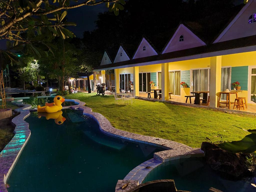 een zwembad met een rubberen eend in het midden van een huis bij Phutawan Resort in Chai Badan
