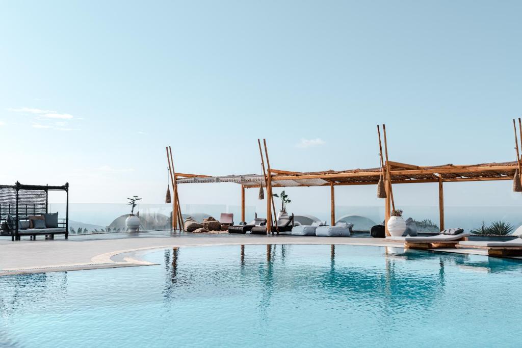 una piscina en un complejo con un pabellón de madera en Orizontes Hotel Santorini, en Pirgos