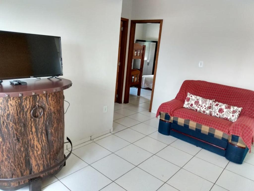 a living room with a couch and a flat screen tv at Casa São José da Barra Capitólio in Elisiário Lemos
