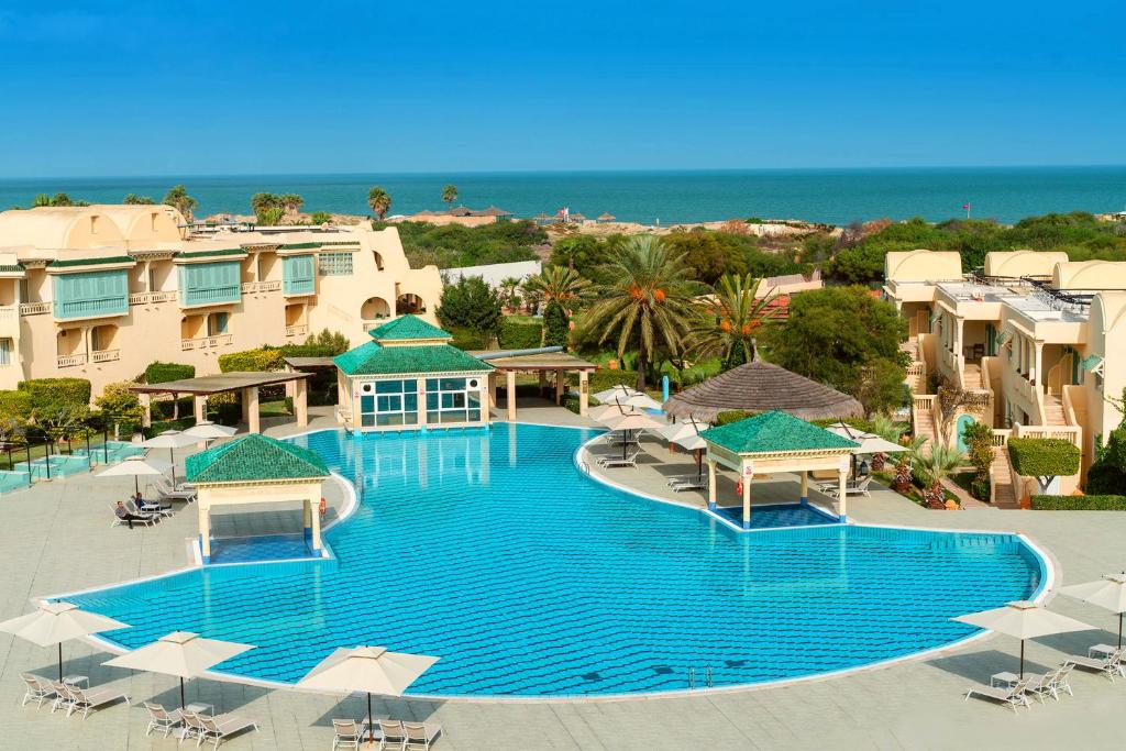 una vista aérea de una gran piscina con sombrillas en Carthage Thalasso Resort, en Gammarth