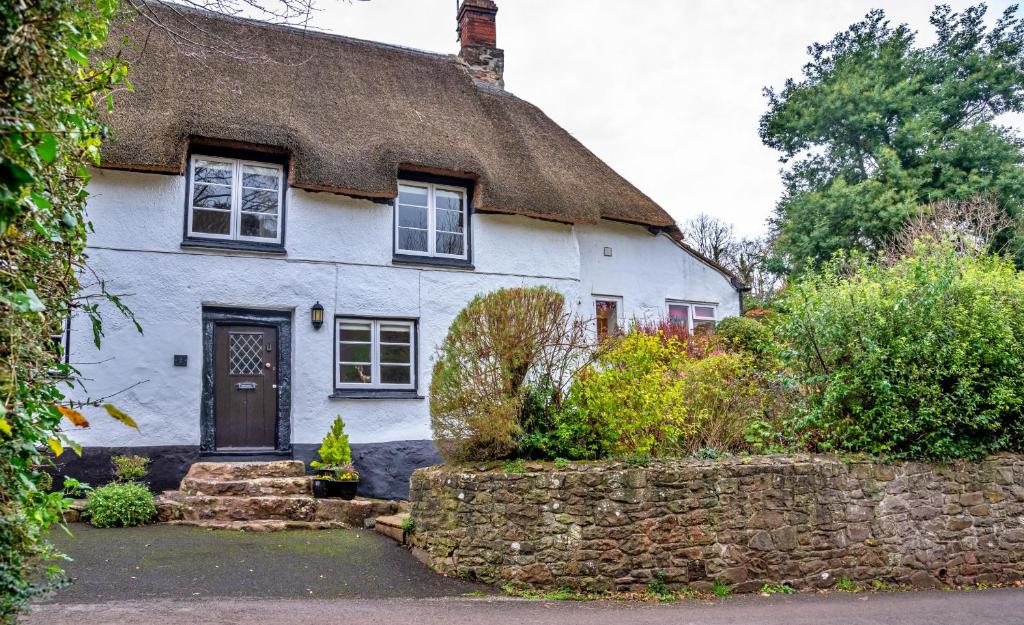 a white house with a thatched roof at Finest Retreats - Little Haven in Minehead