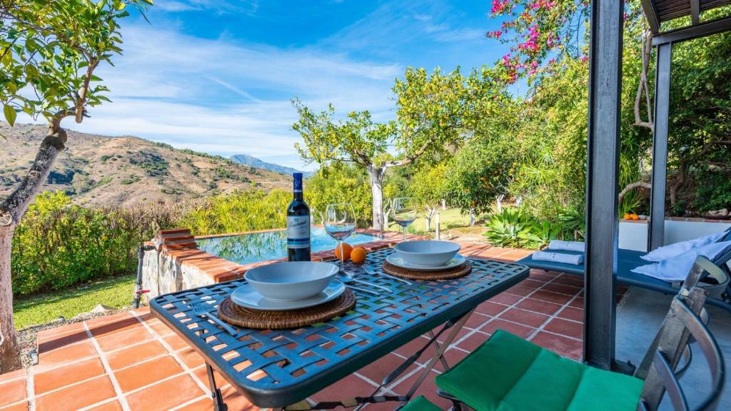 a table with a bottle of wine on a patio at Casa Ami Guaro by Ruralidays in Guaro