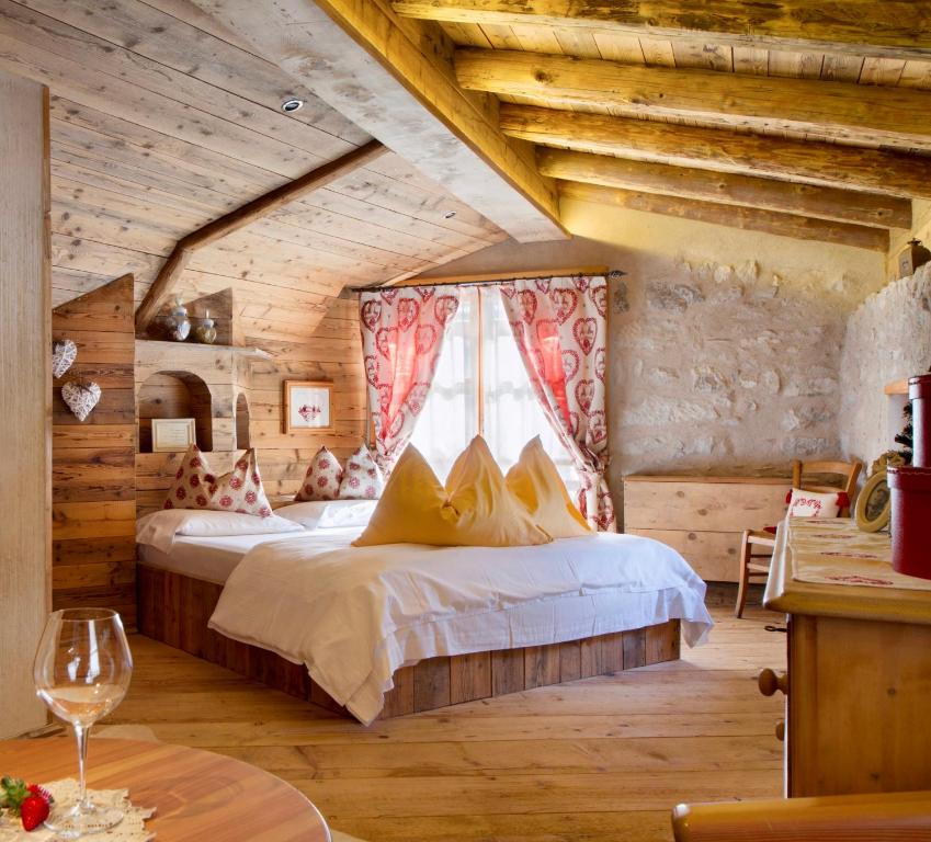 ein Schlafzimmer mit einem Bett in einem Zimmer mit Holzdecken in der Unterkunft Chalet Sogno di Fiaba in Nembia