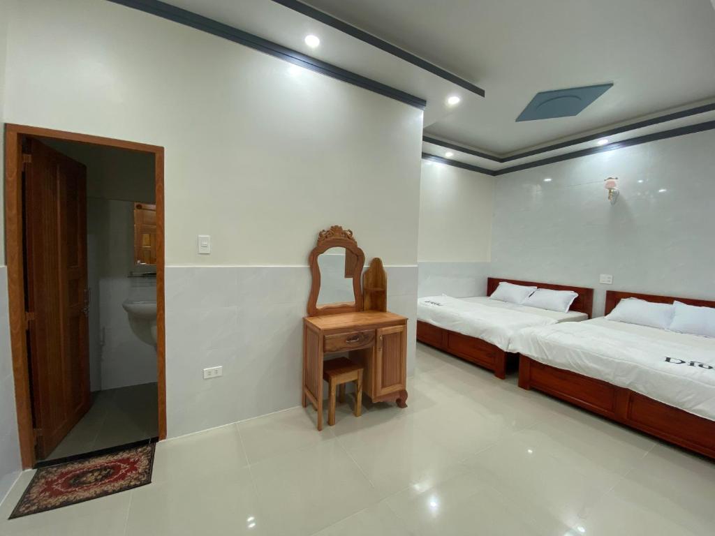 a bedroom with two beds and a toilet in it at Tùng Thủy Homestay - Dinh Thầy Thím Lagi in La Gi
