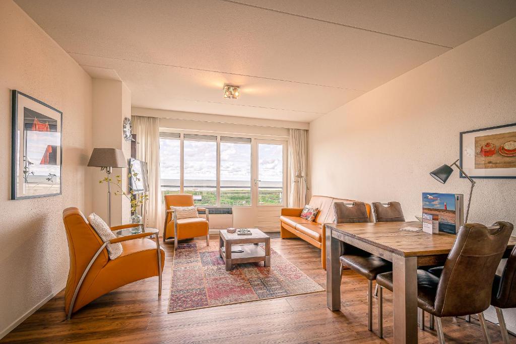 ein Wohnzimmer mit einem Tisch und einem Sofa in der Unterkunft Appartementencomplex Juliana 154 in De Koog