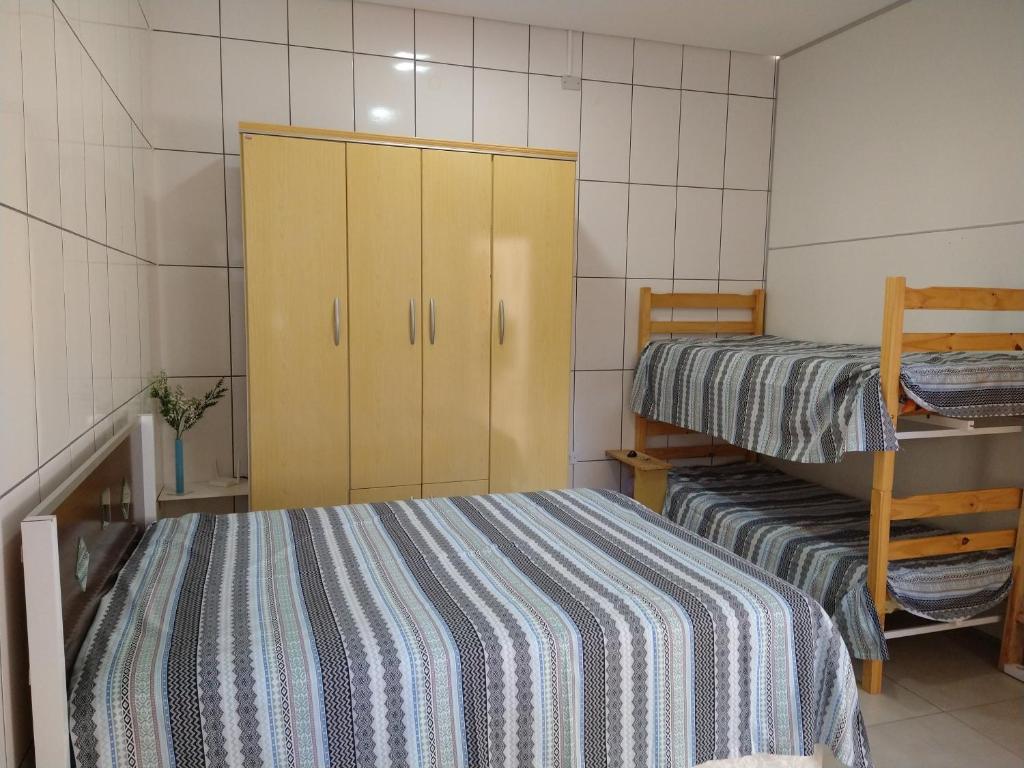 um pequeno quarto com 2 camas e um armário em Espaço coração de mãe em Pirapozinho