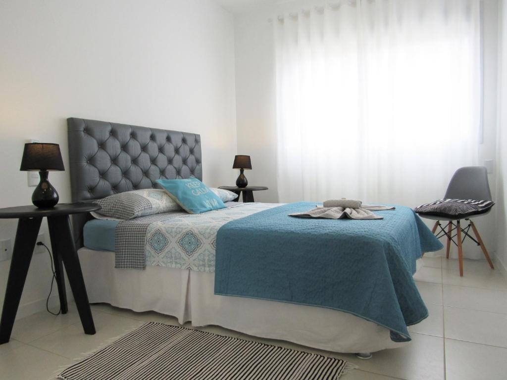 1 dormitorio con 1 cama con manta azul en Apart TOP moderno e completo en Florianópolis