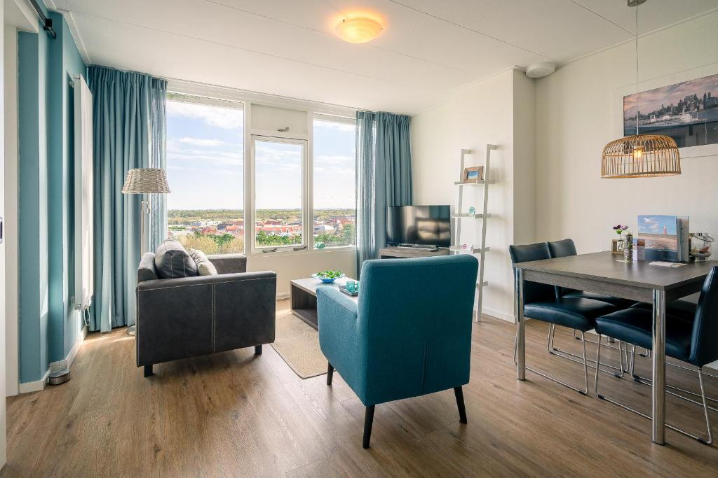 a living room with a table and a dining room at Appartementencomplex Juliana 176 in De Koog