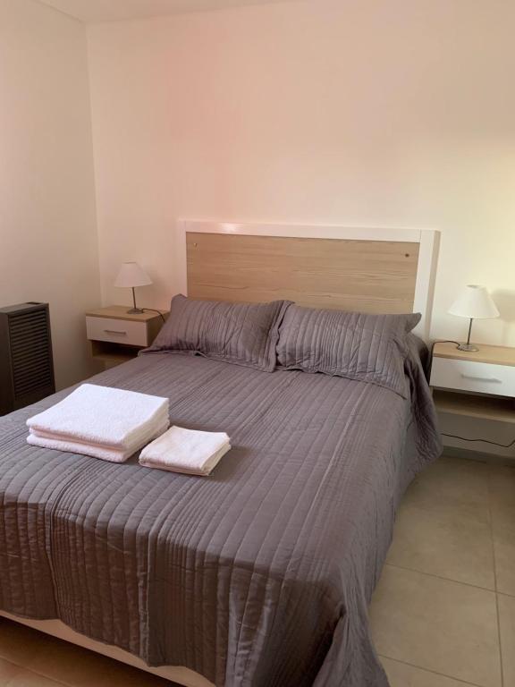 - une chambre avec un grand lit et 2 serviettes dans l'établissement Frente al lago, à San Carlos de Bariloche