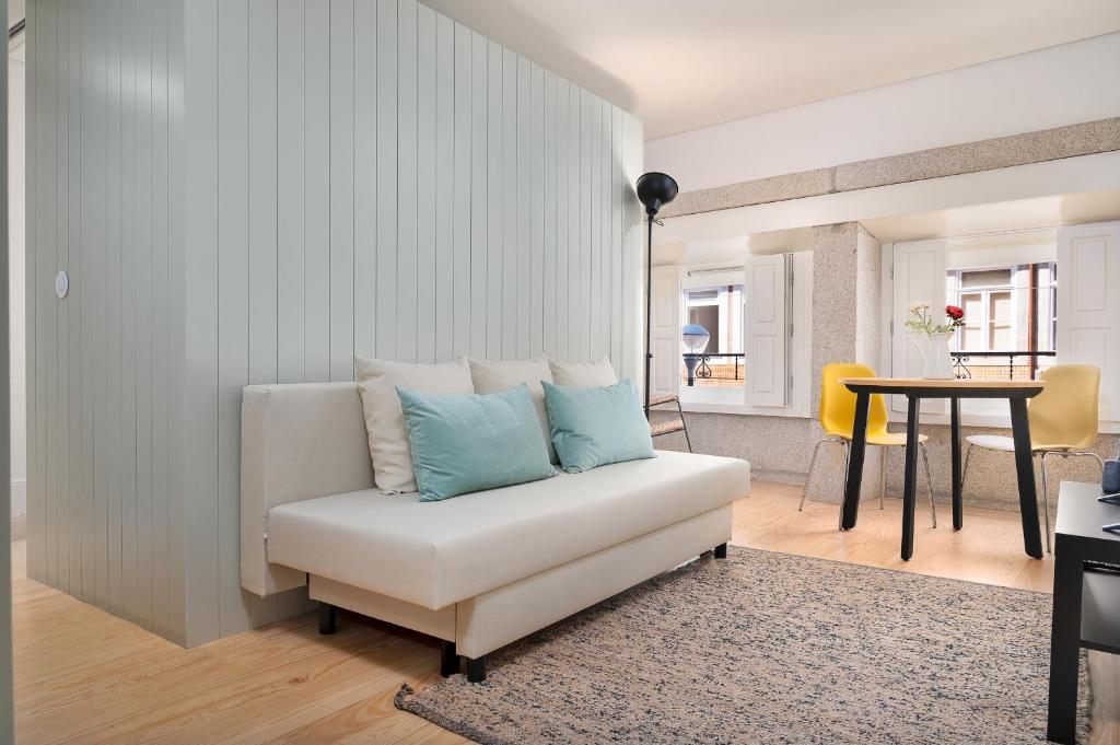 a living room with a white couch with blue pillows at Liiiving in Porto - Santa Catarina Boutique in Porto