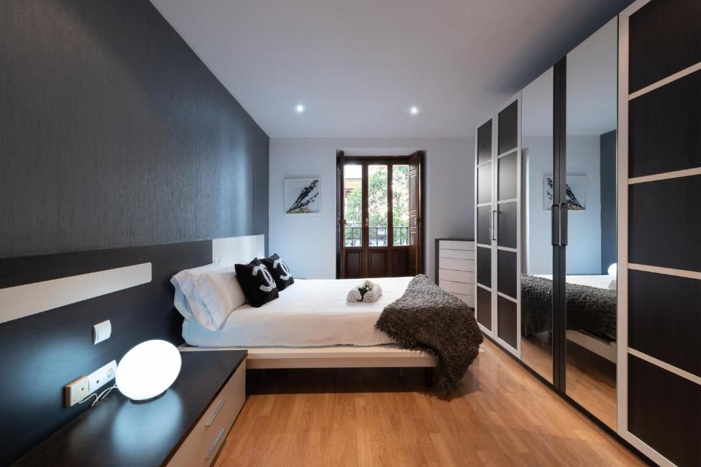1 dormitorio con cama y espejo grande en Apartamentos Day Madrid SAN ANTONIO Centro Gran Via Sol Malasaña, en Madrid