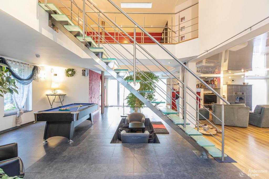 a living room with a pool table and a staircase at Le Loft in Stoumont