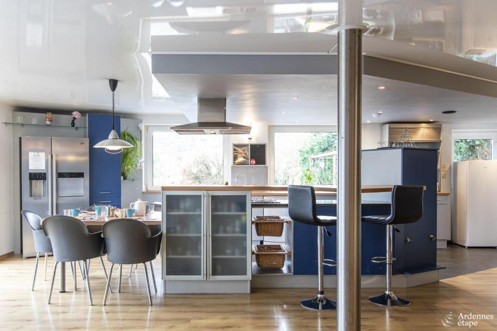 a kitchen with blue walls and a table and chairs at Le Loft in Stoumont