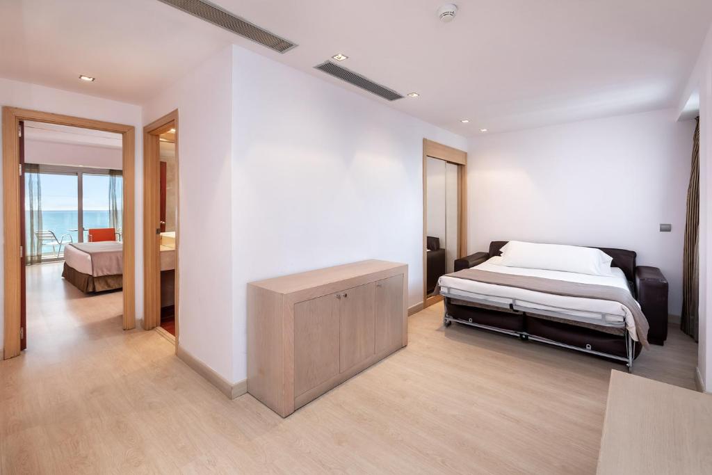 a bedroom with a bed and a dresser in it at Hotel Cristina by Tigotan Las Palmas - Adults Only in Las Palmas de Gran Canaria