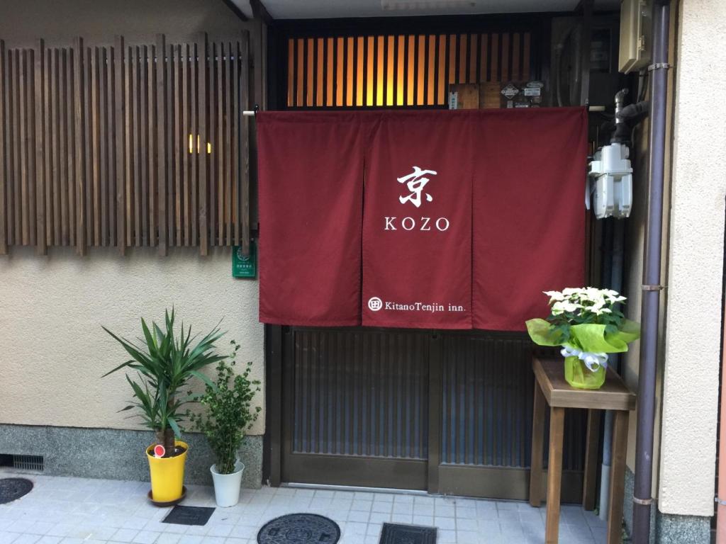 Kyo KOZO Kitano Tenjin - Vacation STAY 89906 في كيوتو: علامة حمراء على جانب مبنى به نباتات