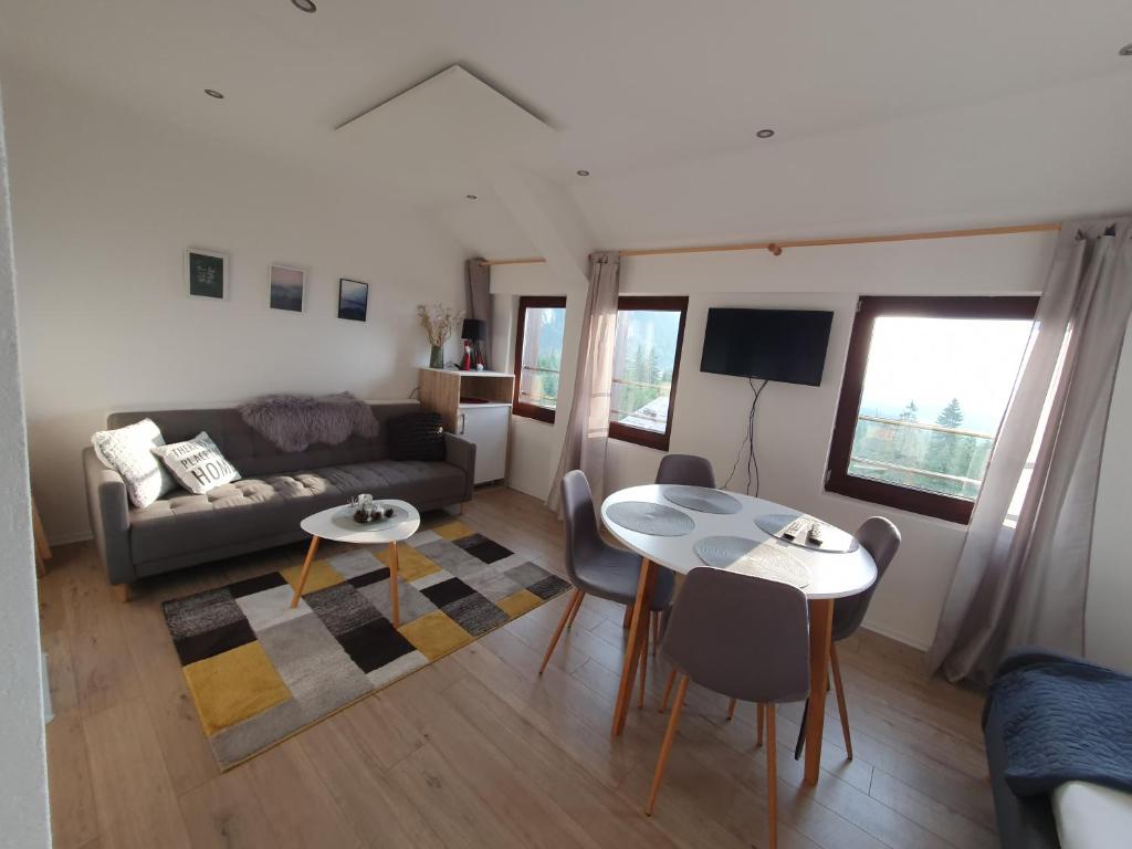 a living room with a couch and a table at Jelka apartmani in Jahorina