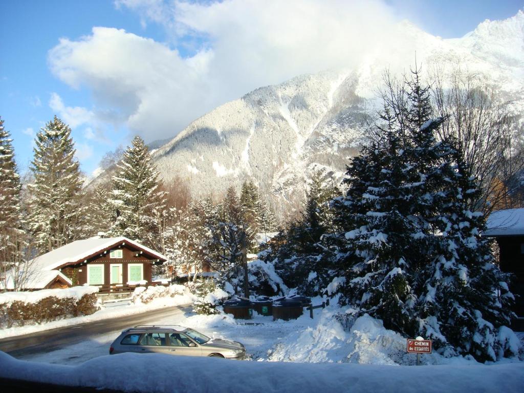 a car parked in front of a house with a snow covered mountain at Chalet de 3 chambres a Chamonix Mont Blanc a 200 m des pistes avec terrasse amenagee et wifi in Chamonix-Mont-Blanc