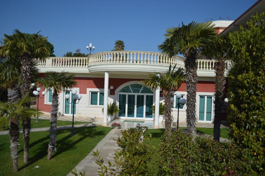 una casa con palme di fronte di Hotel Parco Serrone a Corato