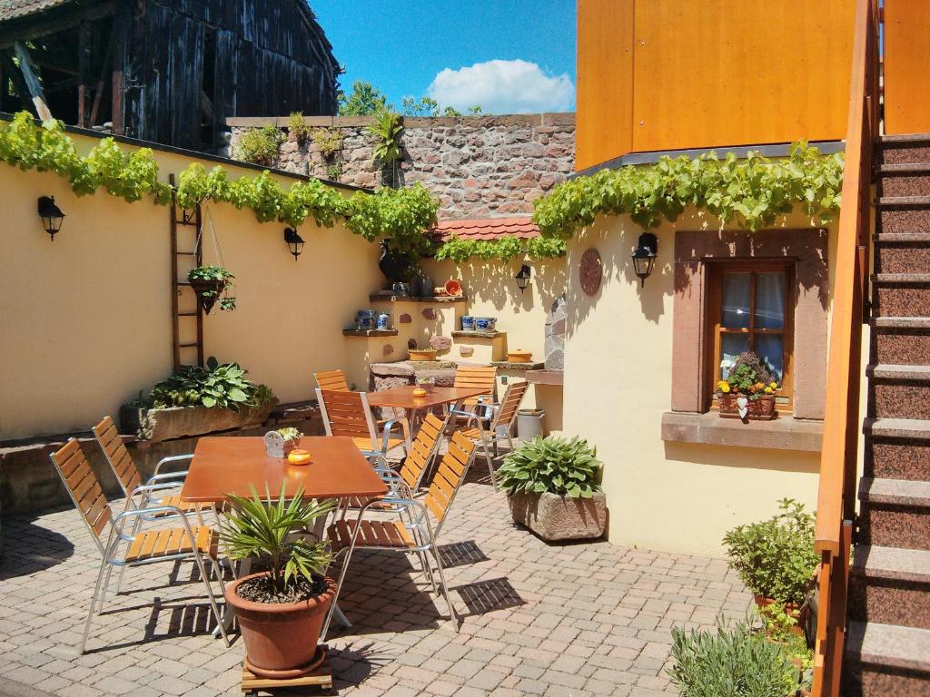 a patio with tables and chairs and a building at Appartement de 2 chambres avec jardin clos et wifi a Beblenheim in Beblenheim