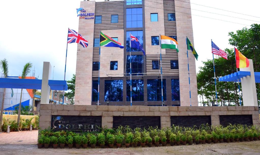 un edificio con diferentes banderas delante de él en The Dolphin Palace, en Chandannagar