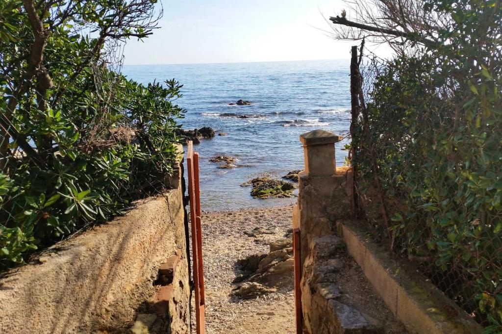 a path leading down to the ocean with a fence at Appartement charmant à Saint-Aygulf avec jardin privé in Saint-Aygulf