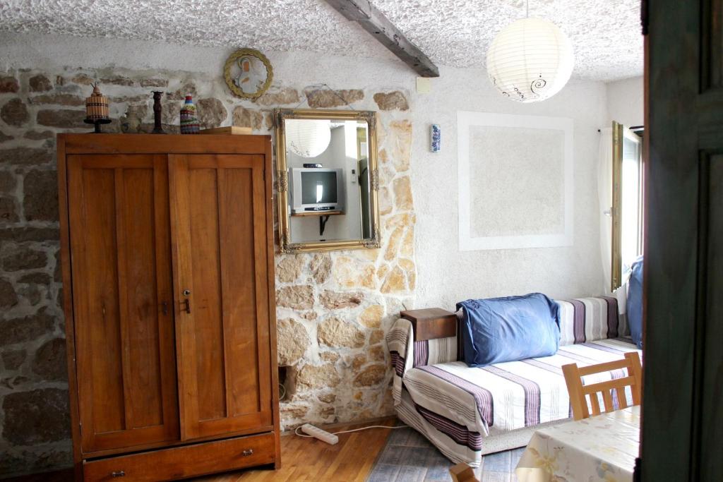 a living room with a couch and a mirror at Charming Studio in Betina, 30 m², Terrace in Betina
