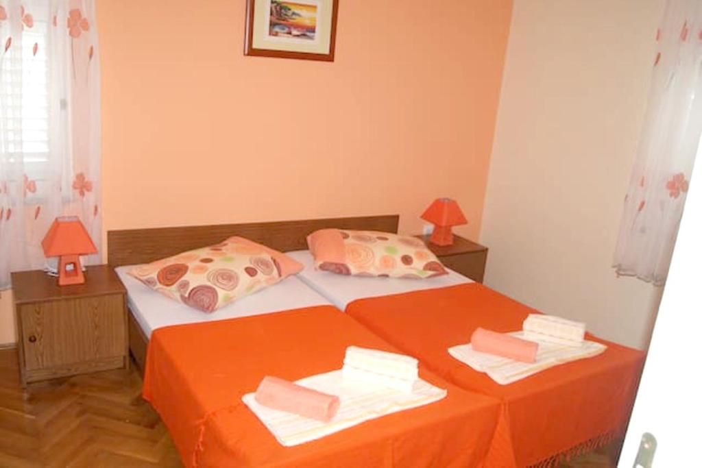 - une chambre avec un lit doté de draps et d'oreillers orange dans l'établissement One bedroom appartement with wifi at Zadar, à Zadar