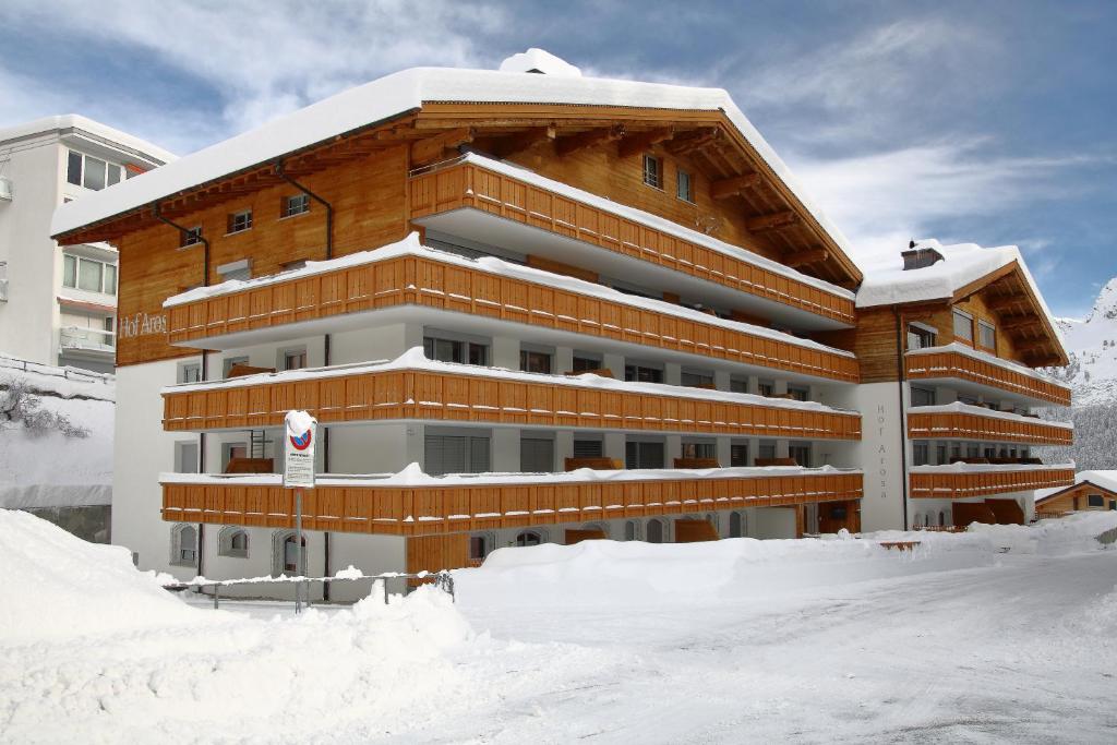 a large building with snow in front of it at Hof Arosa in Arosa