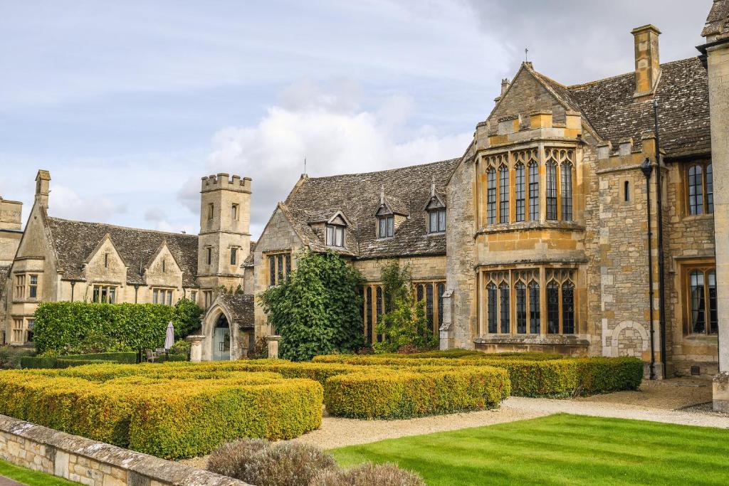 a large green garden with a large clock tower at Ellenborough Park in Cheltenham