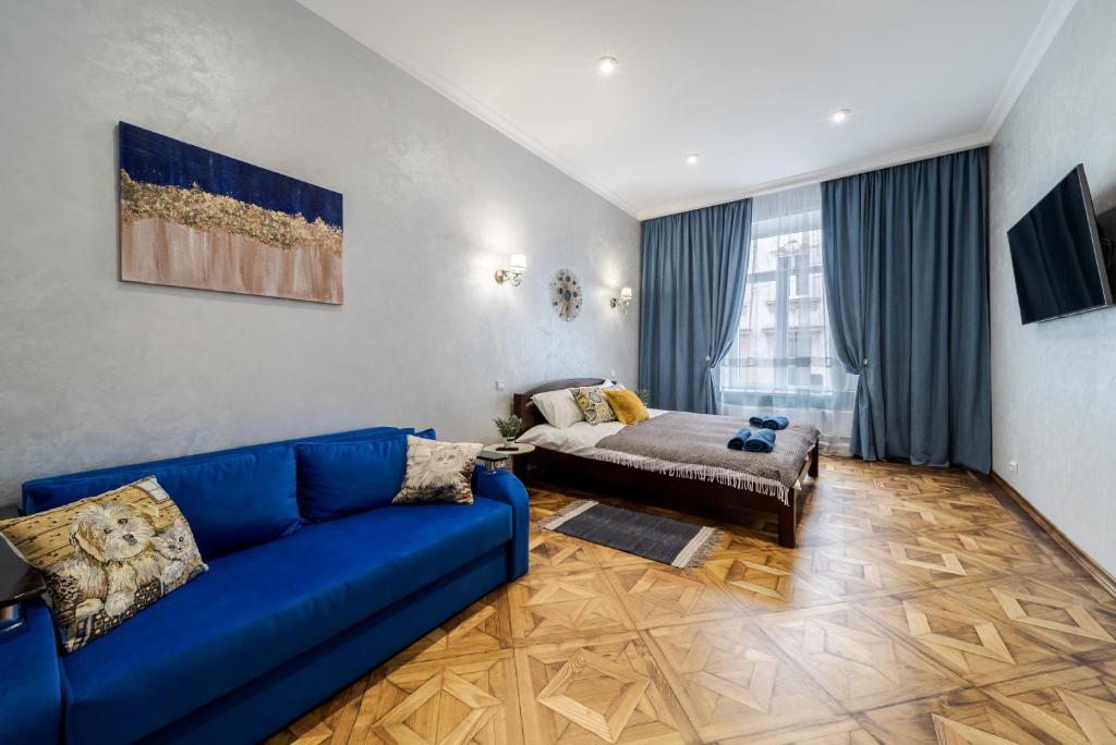uma sala de estar com um sofá azul e uma cama em Райська Насолода em Lviv