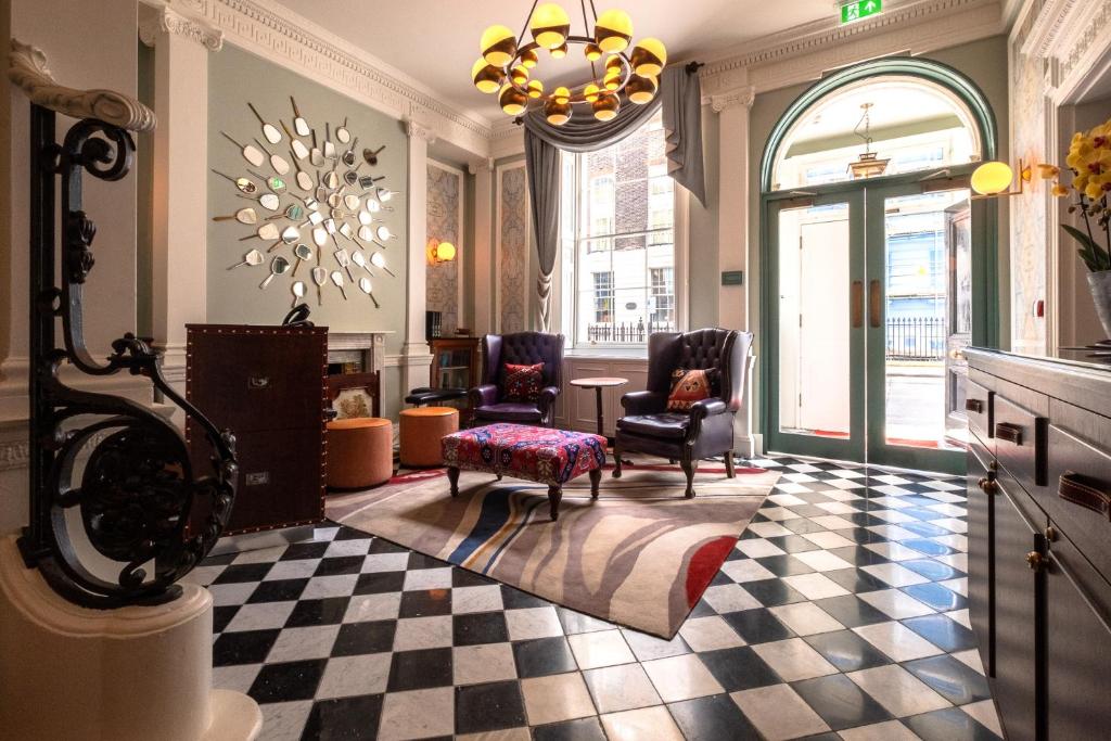 uma sala de estar com cadeiras e um piso em xadrez em Home Grown Club em Londres