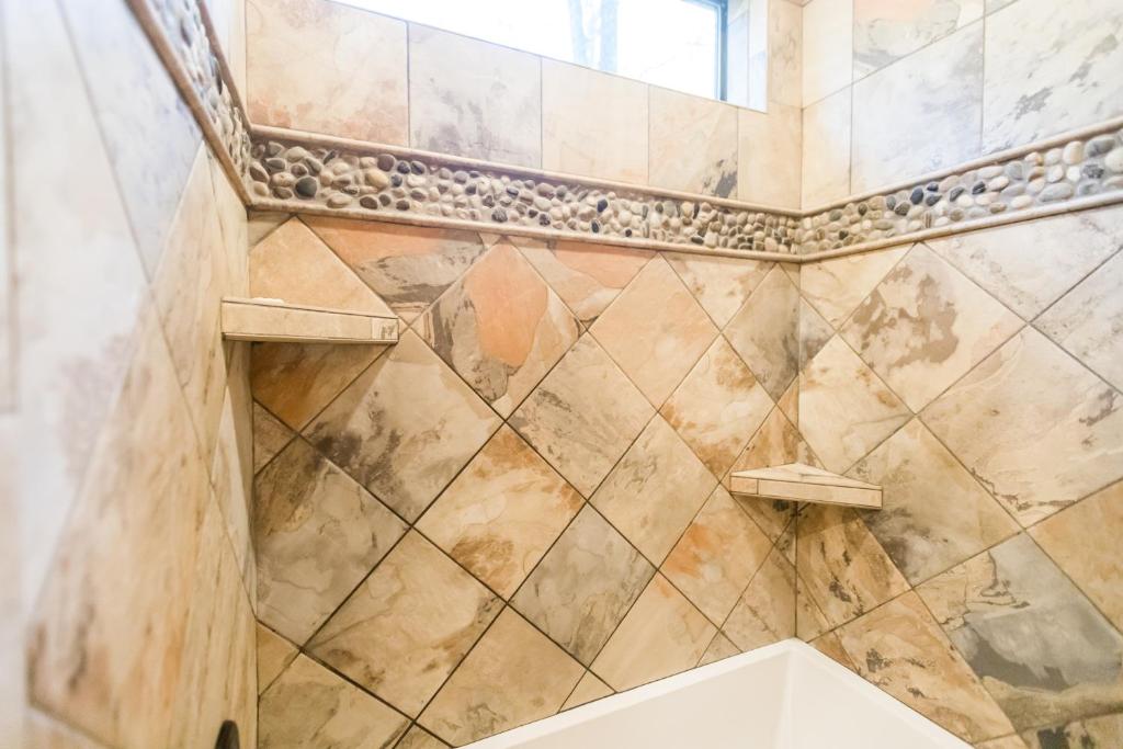 a bathroom with a tiled shower with a window at Time Well Wasted in Stephens Gap