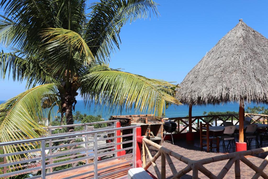 a resort with a palm tree and a table and chairs at Posada Las Graditas in Sayulita