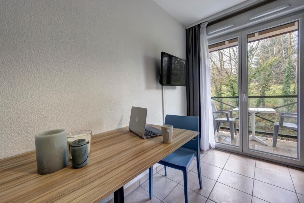 TV a/nebo společenská místnost v ubytování Comfort Aparthotel Divonne L'Orée du Parc