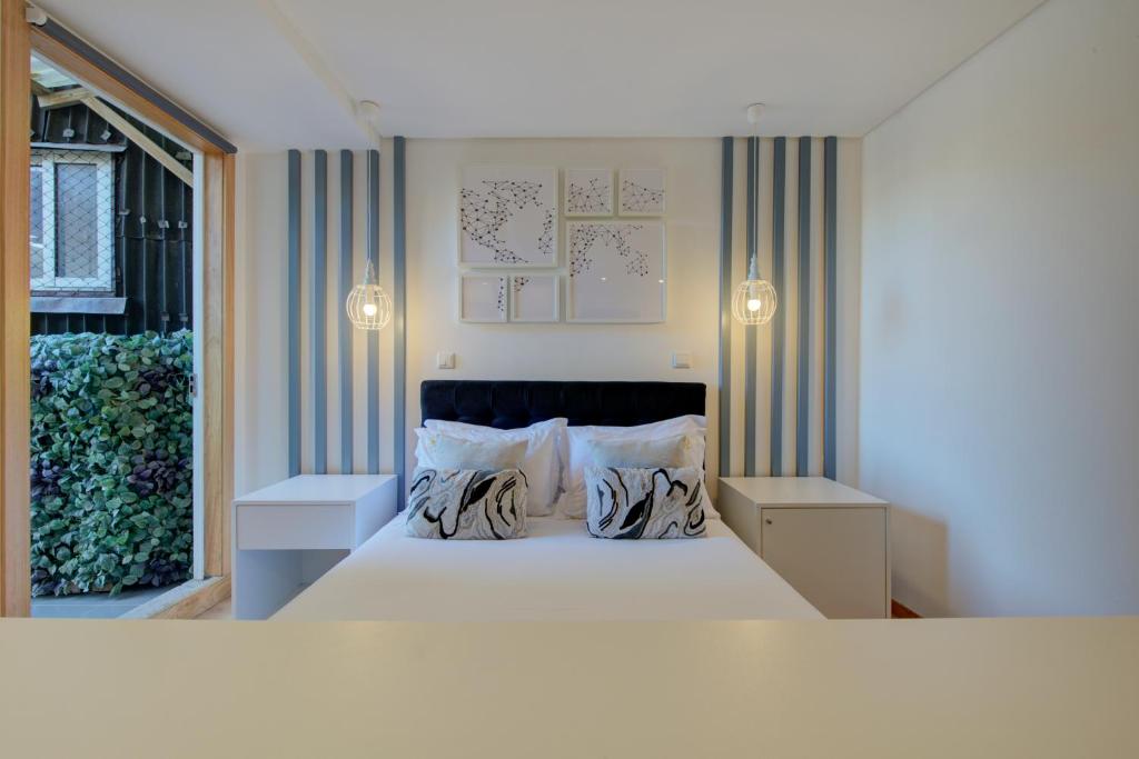a bedroom with a large bed with two pillows at Bellu Suites in Guimarães