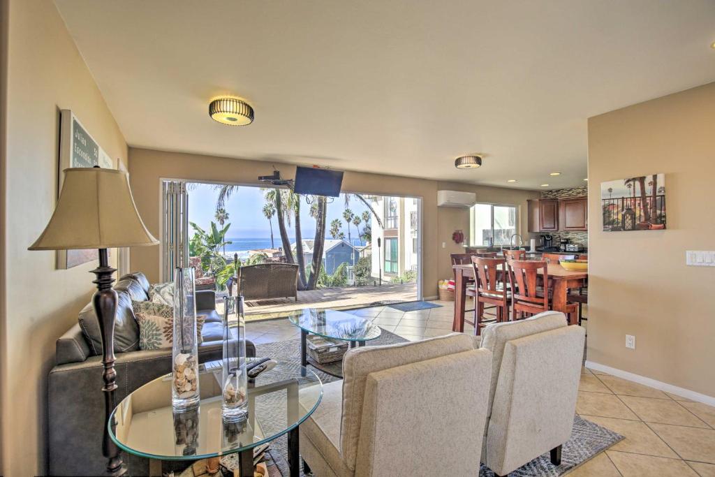 a living room with a glass table and chairs at Tropical Home - 200-Yard Walk to Beach Entrance! in Oceanside