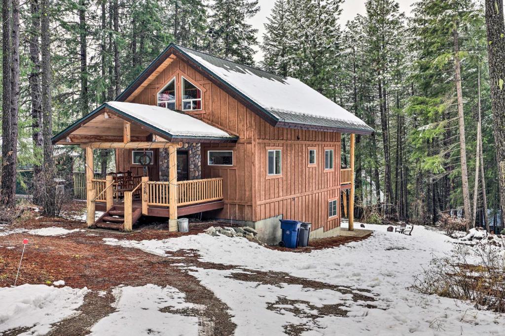 a log cabin in the woods in the snow at Beautiful Leavenworth Cabin Getaway with Hot Tub! in Leavenworth