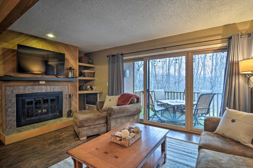 a living room with a couch and a fireplace at Cozy Bellaire Condo with Balcony - 3 Mi to Skiing! in Bellaire